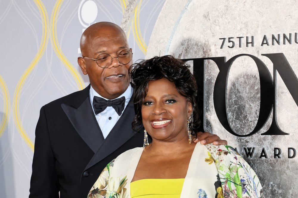 Two actors standing together at a red-carpet photo shoot.