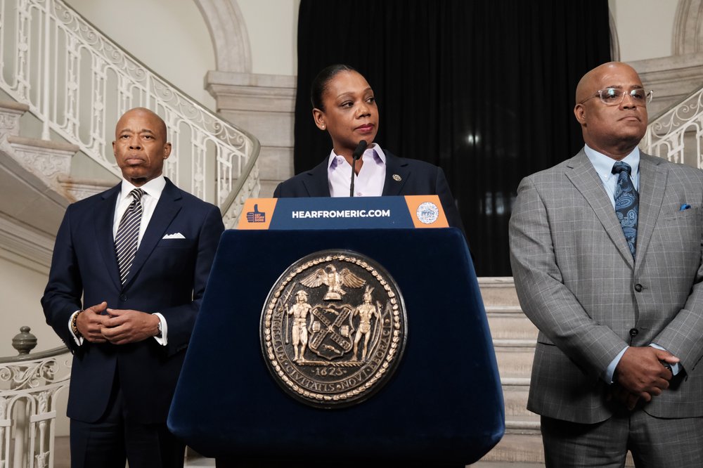 Three people standing near a lectern.