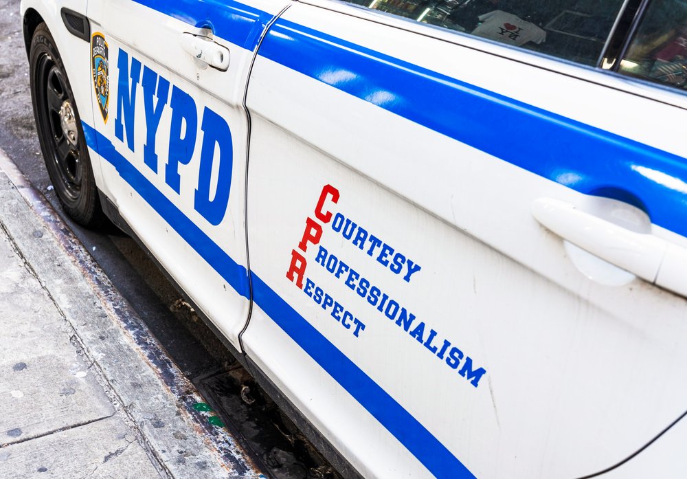 The side of a NYPD police car parked on a street.