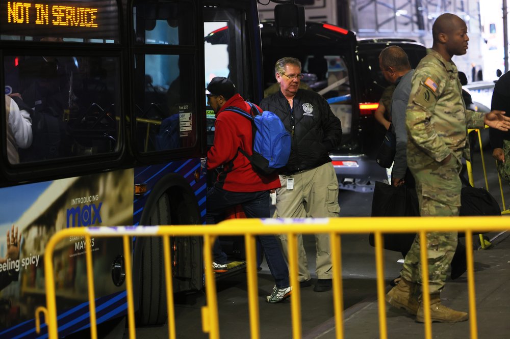 Migrants board a bus.