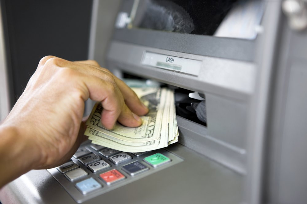 Money being taken from an automated teller machine.