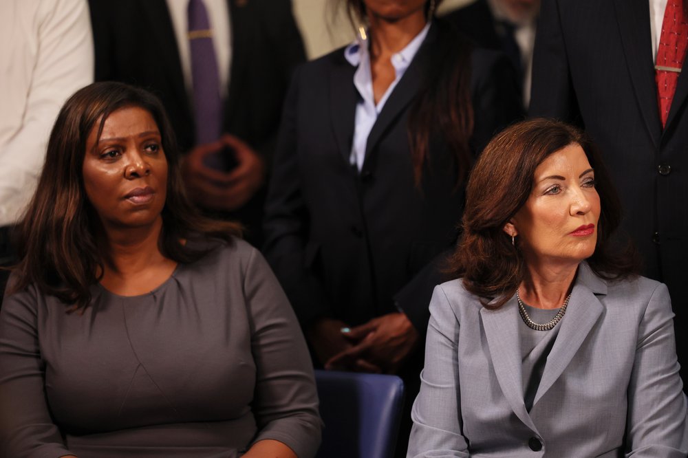 Attorney General Letitia James and Gov. Kathy Hochul sit alongside each other at a press conference.