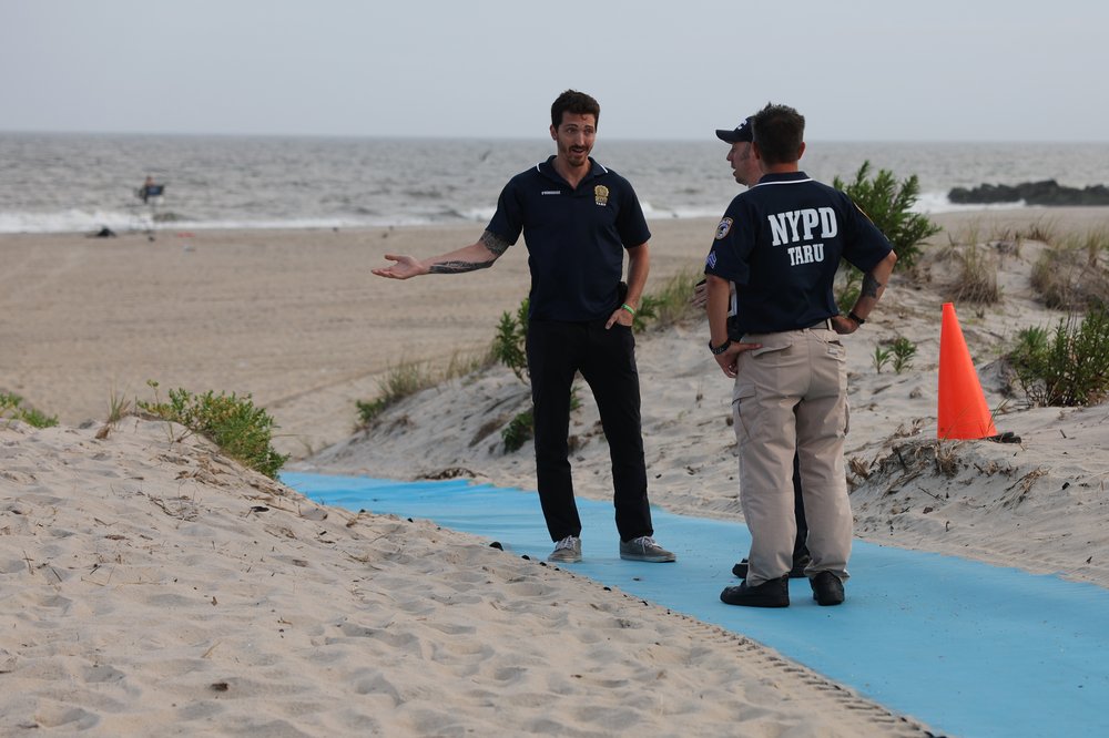 Police gather along Rockaway Beach at 59th Street after a woman was attacked by a shark in the early evening on Aug. 7, 2023.