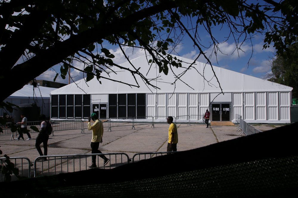 People walk outside the humanitarian relief center at the Creedmoor Psychiatric Center in Queens on Aug. 16, 2023. The center has capacity to shelter up to 1,000 single adult male migrants.