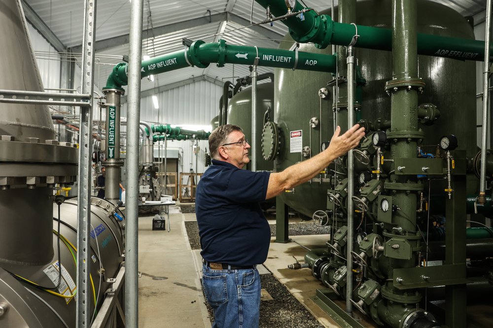 A man holds his hand up in a water treatment plant
