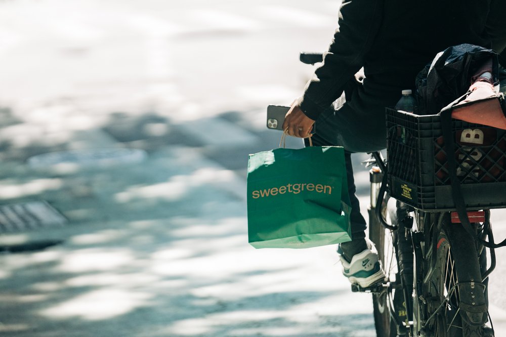 A food delivery messenger carries a take out bag outside a Sweetgreen in Manhattan.