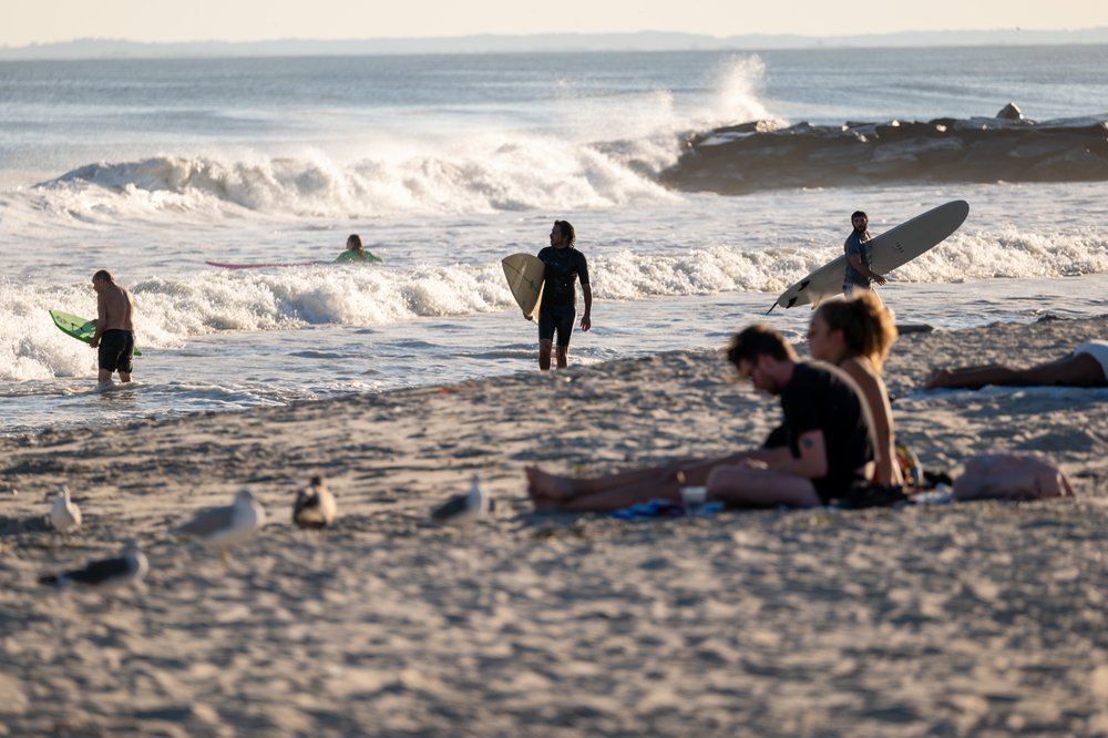 Surfers and others spend a day at Rockaway Beach in 2023.
