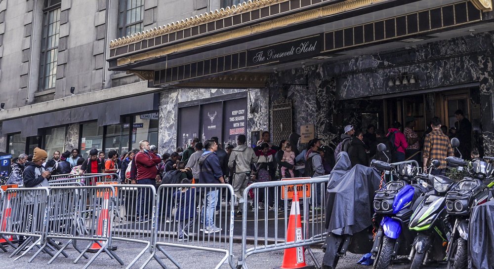 Asylum-seekers line up in front of the historic Roosevelt Hotel, converted into a city-run shelter for newly arrived migrant families in Manhattan on Sept. 27.
