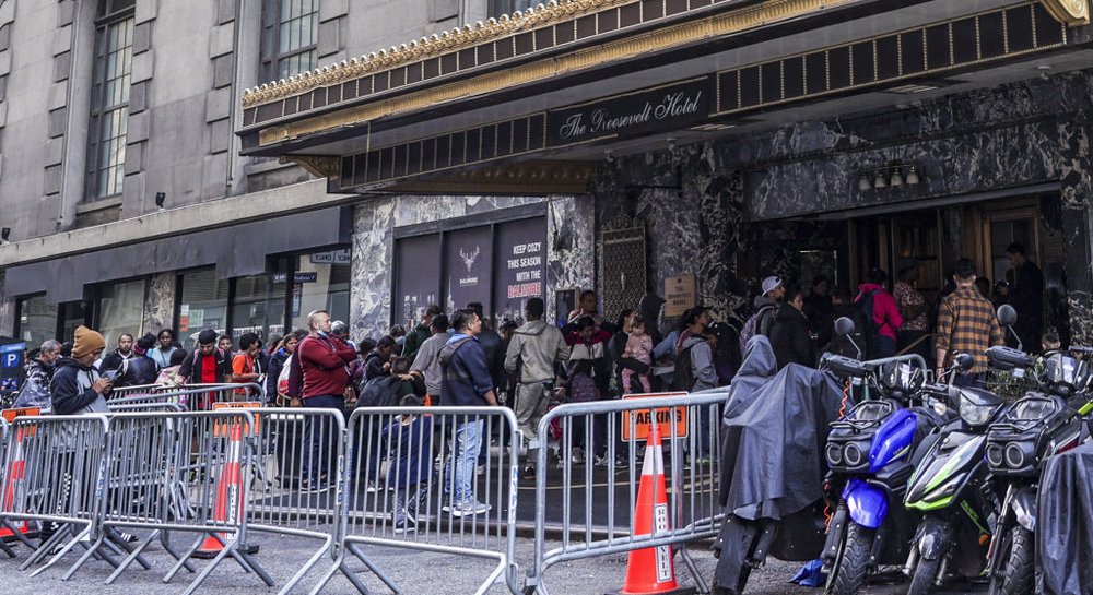 Asylum-seekers line up in front of the Roosevelt Hotel, the main intake center for migrants, Roosevelt Hotel, on Sept. 27.