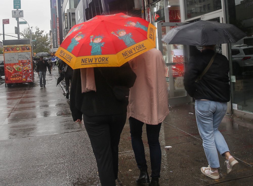 People walk with umbrellas in New York City during the remnants of Tropical Storm Ophelia on Sept. 29, 2023.