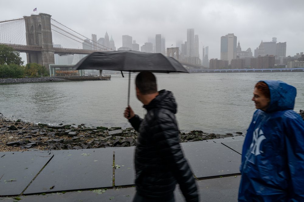 People walk through Brooklyn during heavy rain and high winds as the remnants of Tropical Storm Ophelia continue to move through the area on Sept. 25, 2023 in New York City.