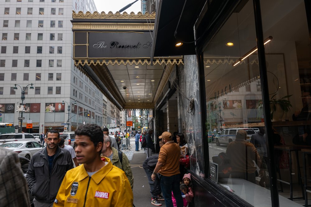 Recently arrived migrants congregate outside of the Roosevelt Hotel in Midtown.