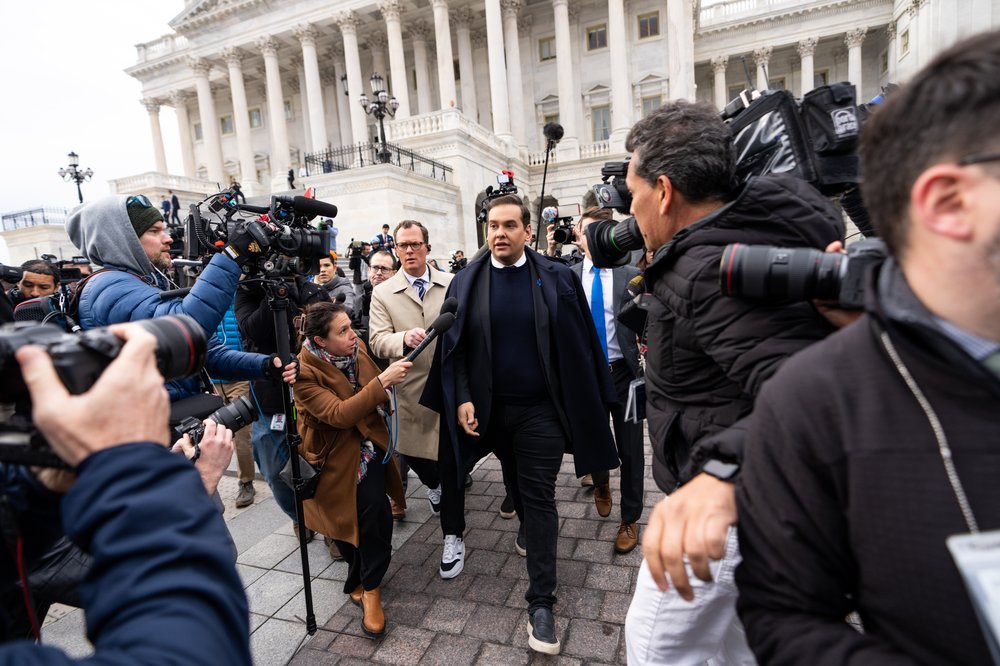 Rep. George Santos wades through a crush of people and reporters outside of the U.S. Capitol building.