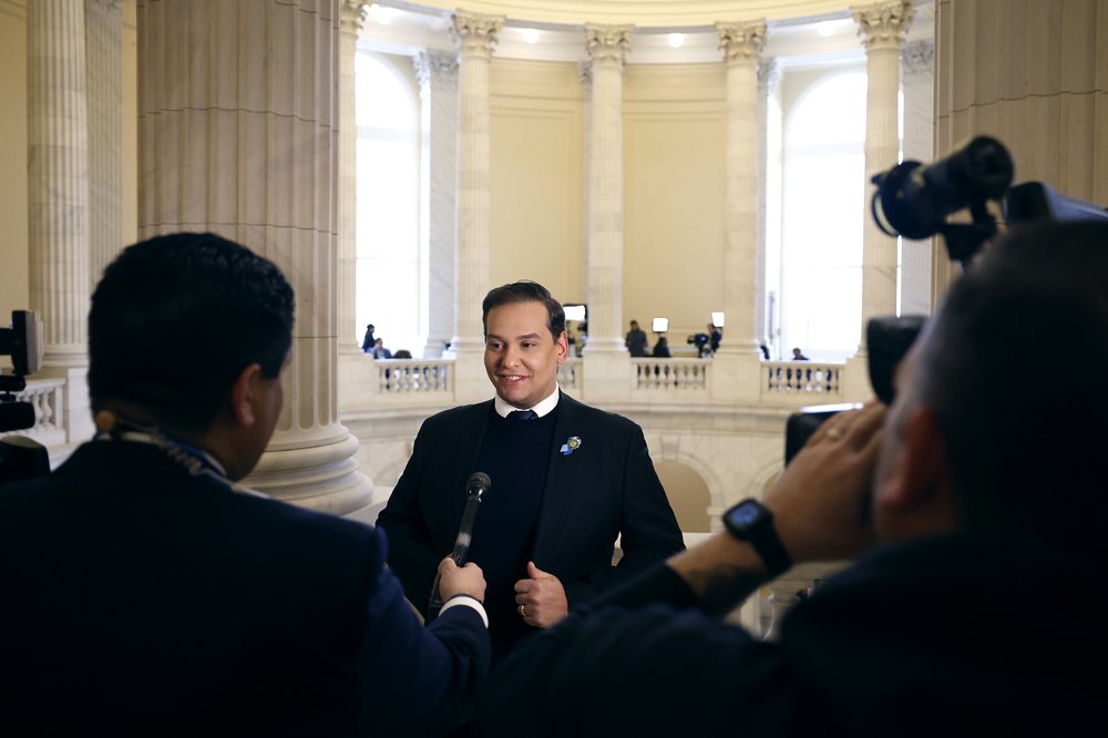 Rep. George Santos in the rotunda of the Cannon House Office Building being interviewed by reporters.