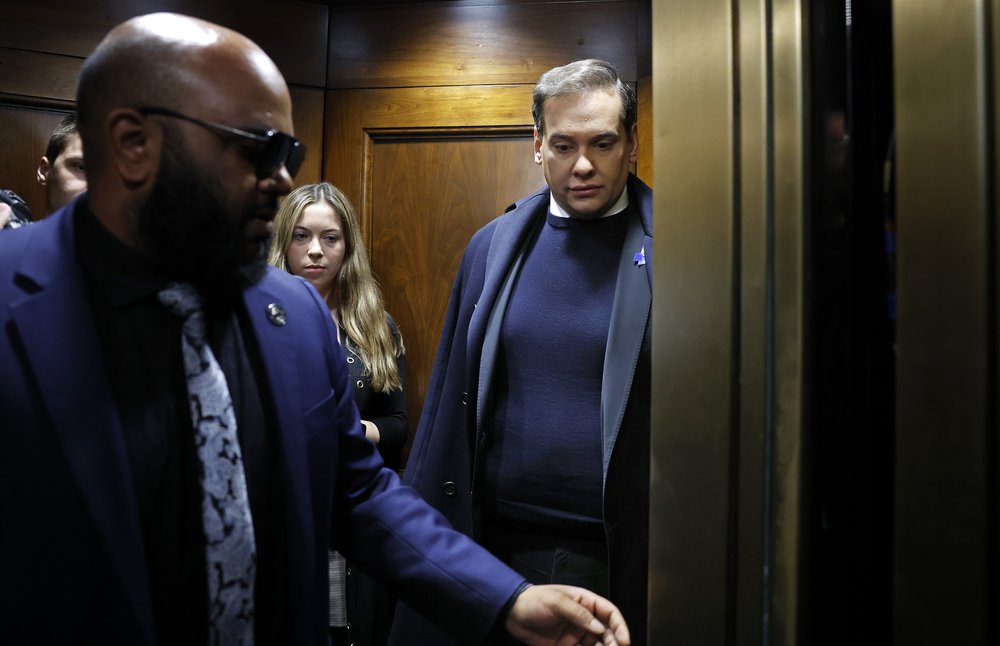 Former Rep. George Santos and members of his staff board an elevator as they head for the U.S. Capitol ahead of a vote to expel him from the House of Representatives on Dec. 1, 2023.