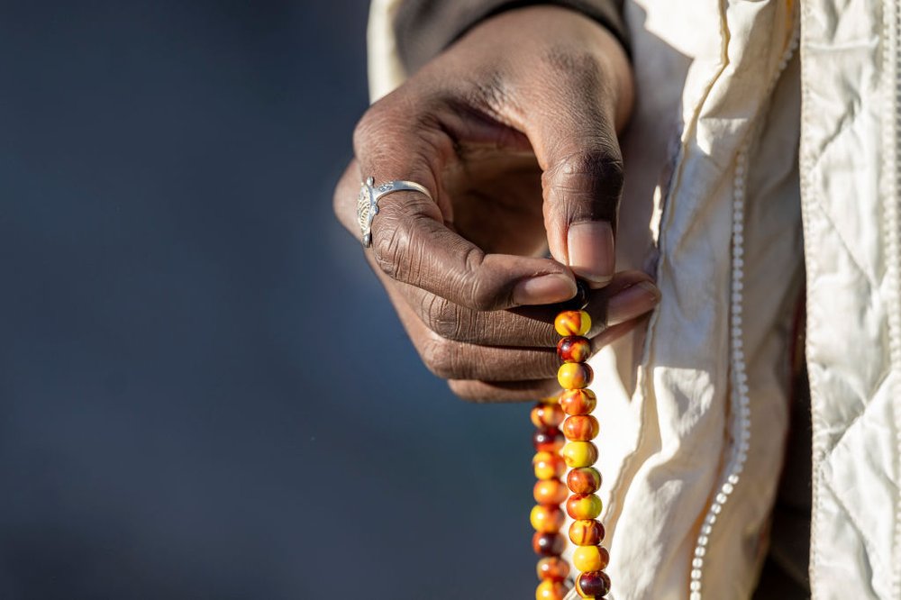 A migrant from Mauritania fingers prayer beads while waiting to be processed by U.S. border authorities on Dec. 5, 2023, in Lukeville, Arizona. A surge in border crossings has sent thousands of West African migrants to parts north, including New York City.