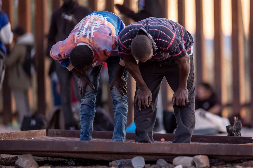 Immigrants from Senegal take part in an Islamic prayer at sunset while waiting with other migrants to be transported from the U.S.-Mexico border on Dec. 6, 2023 in Lukeville, Arizona. Thousands of migrants from West African nations have made their way to New York City, as part of an influx that began two years ago.