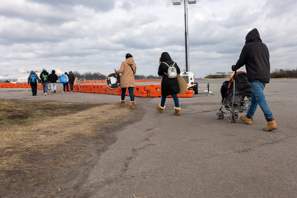 Recently arrived migrants walk from their temporary tent shelters at Floyd Bennett Field, a former airfield in Brooklyn, on Jan. 4, 2024.