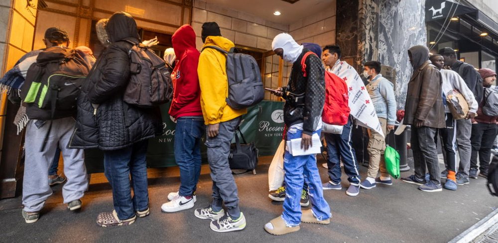 A line of people with bags wait outside of the Roosevelt Hotel in Midtown.