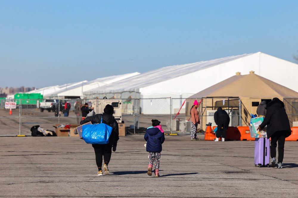 Recently arrived migrants walk to the Floyd Bennett Field humanitarian relief center on Feb. 3, 2024.