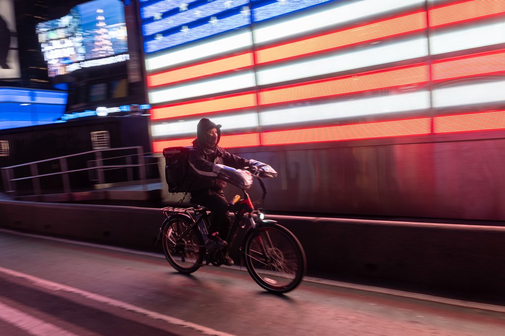 A food delivery worker uses an electric bicycle in Times Square on February 06, 2024 in New York City.