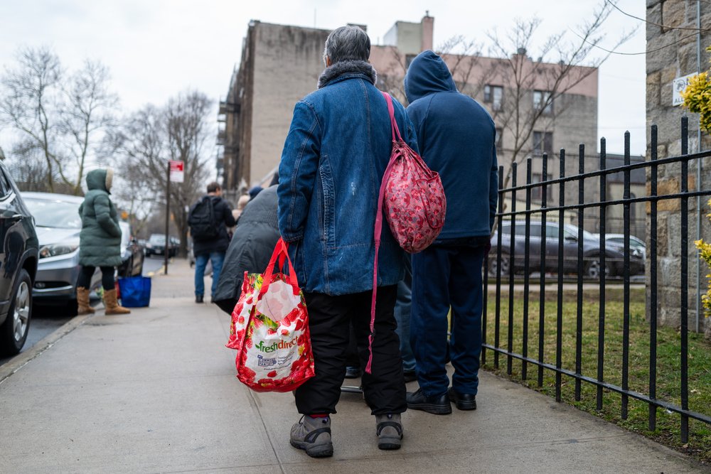People wait in line as free food is distributed to residents in need at a weekly food bank at Our Lady of Refuge Church in Brooklyn on Feb. 28, 2024.