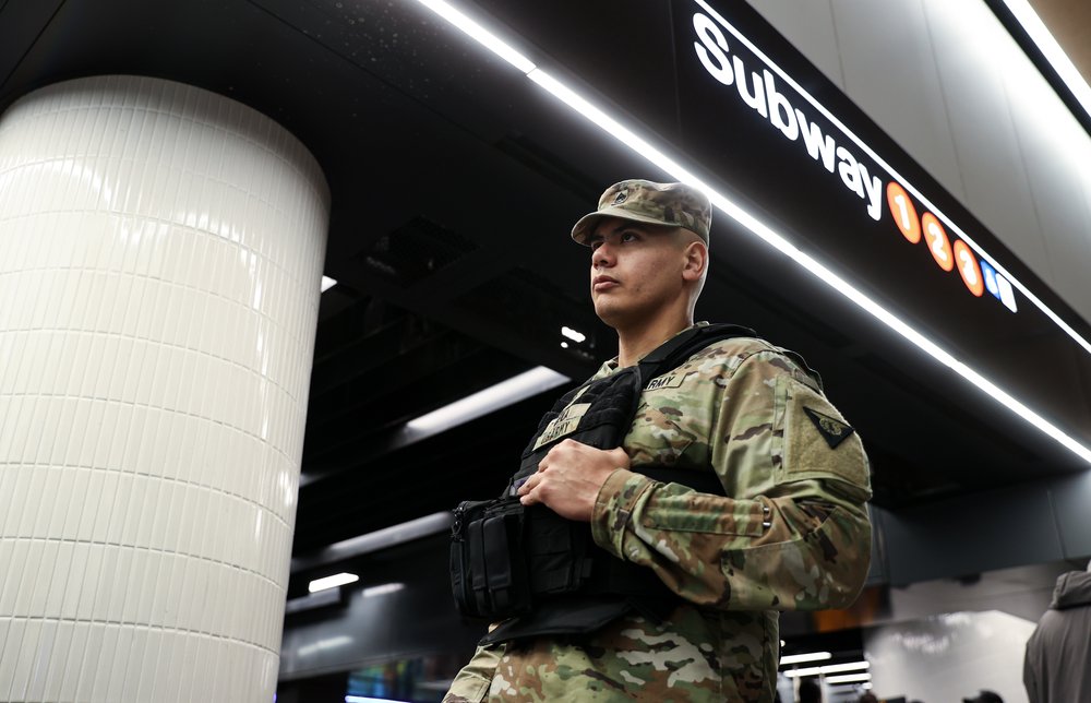 Security forces, including National Guard troops and police, take security measures at a subway station in New York.
