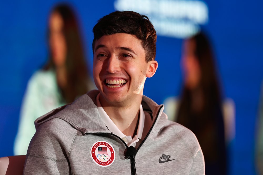 A person smiles wearing a gray hoodie that says "United States Olympic Team."