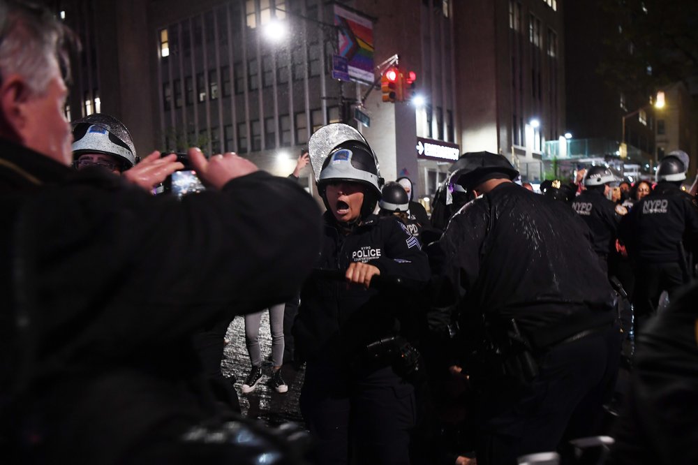 A police officer urges a man who is filming near Columbia University to leave in New York in April as dozens of protesters who occupied a building of Columbia University in protest of Israeli operation in Gaza were arrested.