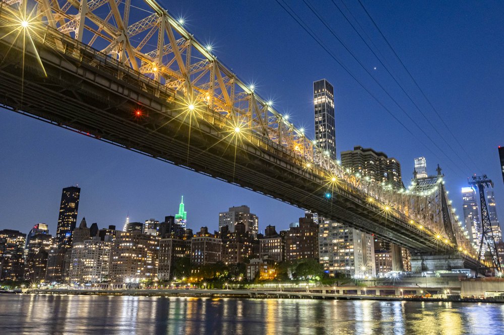 The Queensboro Bridge lit up at night.