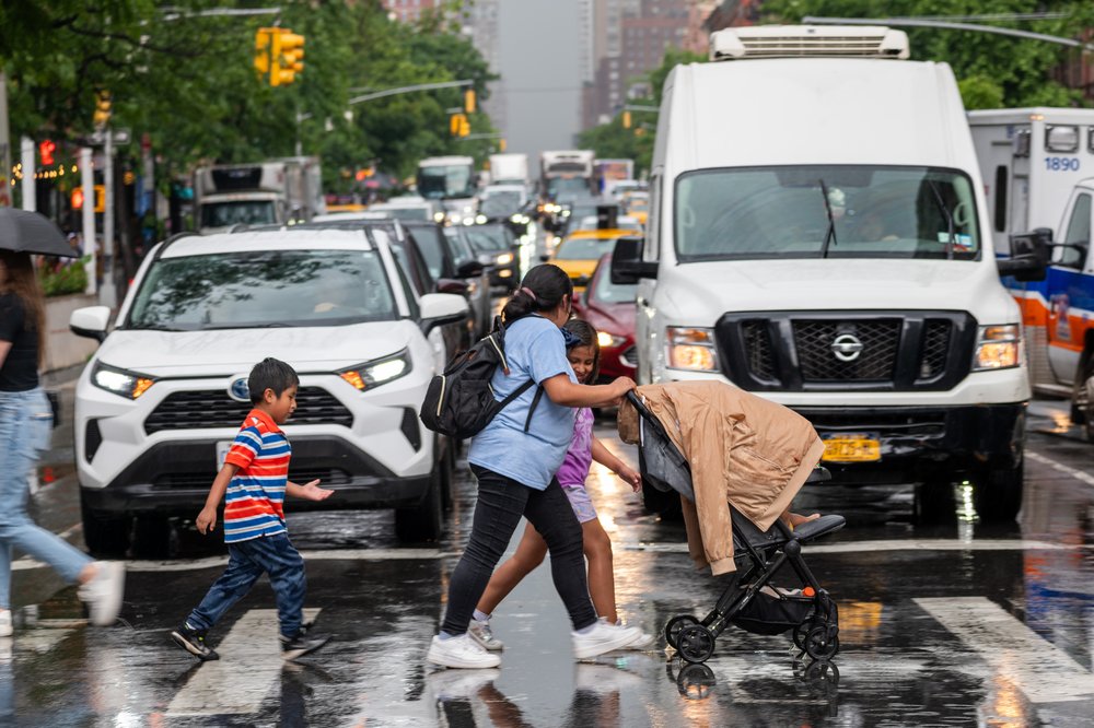 Pedestrians walk in front of gridlocked traffic in Manhattan.