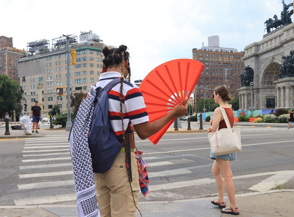 People prepare to cross the street near Grand Army Plaza in Brooklyn during hot weather on June 24, 2024.
