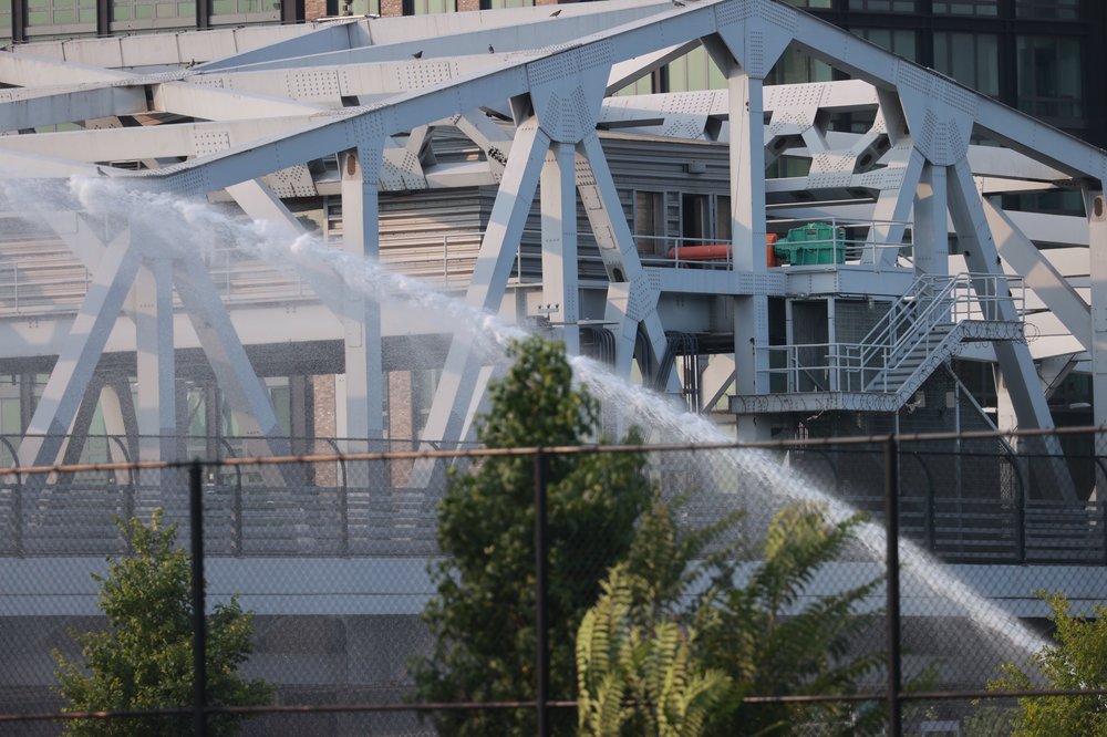Officials spray water onto the Third Avenue Bridge in an attempt to cool it down after getting stuck on Monday.