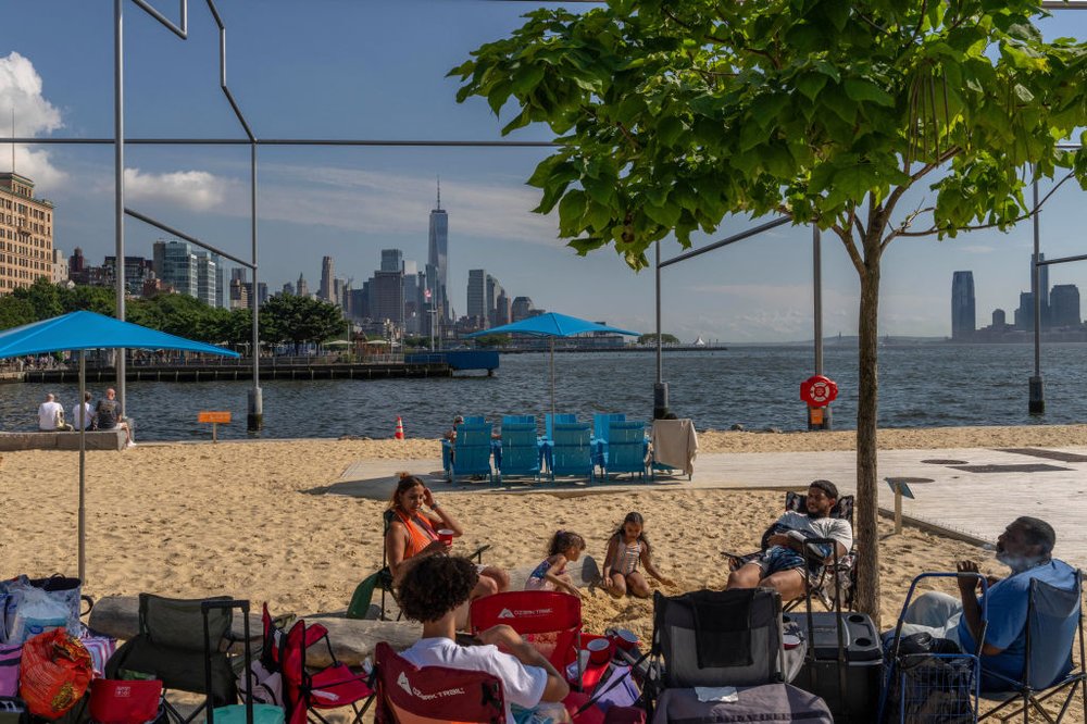 People gather on a beach in Manhattan during hot weather on July 13, 2024.