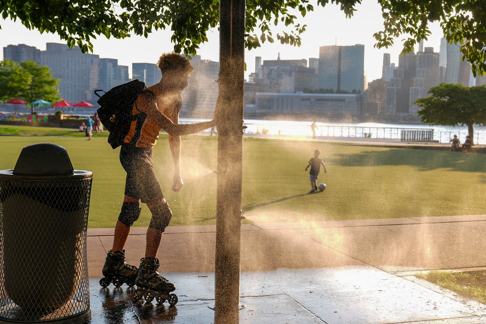 A skater tries to cool off with a sprinkler during a hot day in 2024.