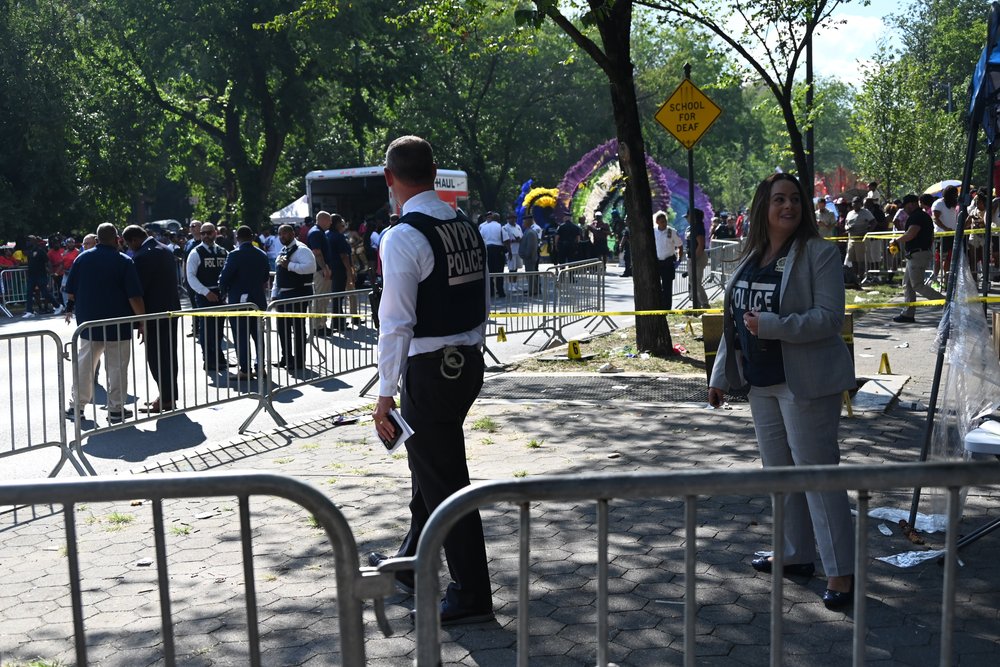 Officers stand behind a police barricade.