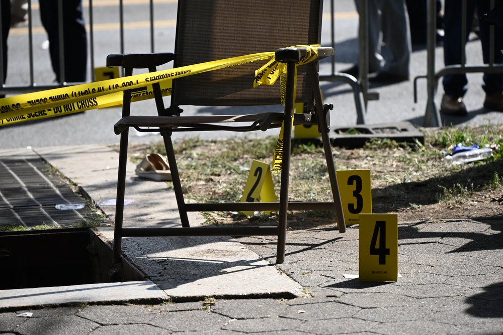 A chair with police tape and number markers outside.