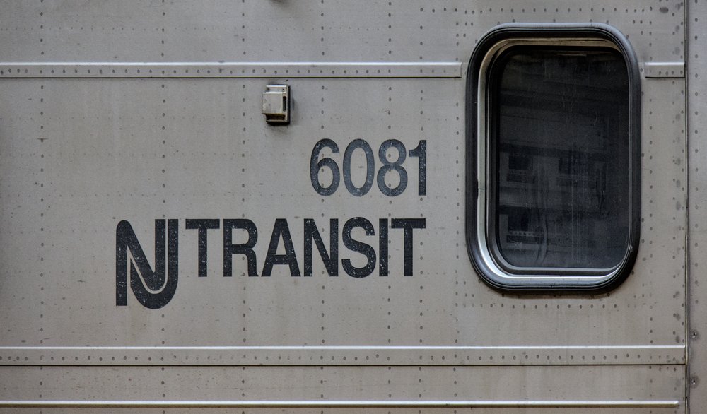 NJT New Jersey Transit logo next to window on a commuter train car numbered 6081.