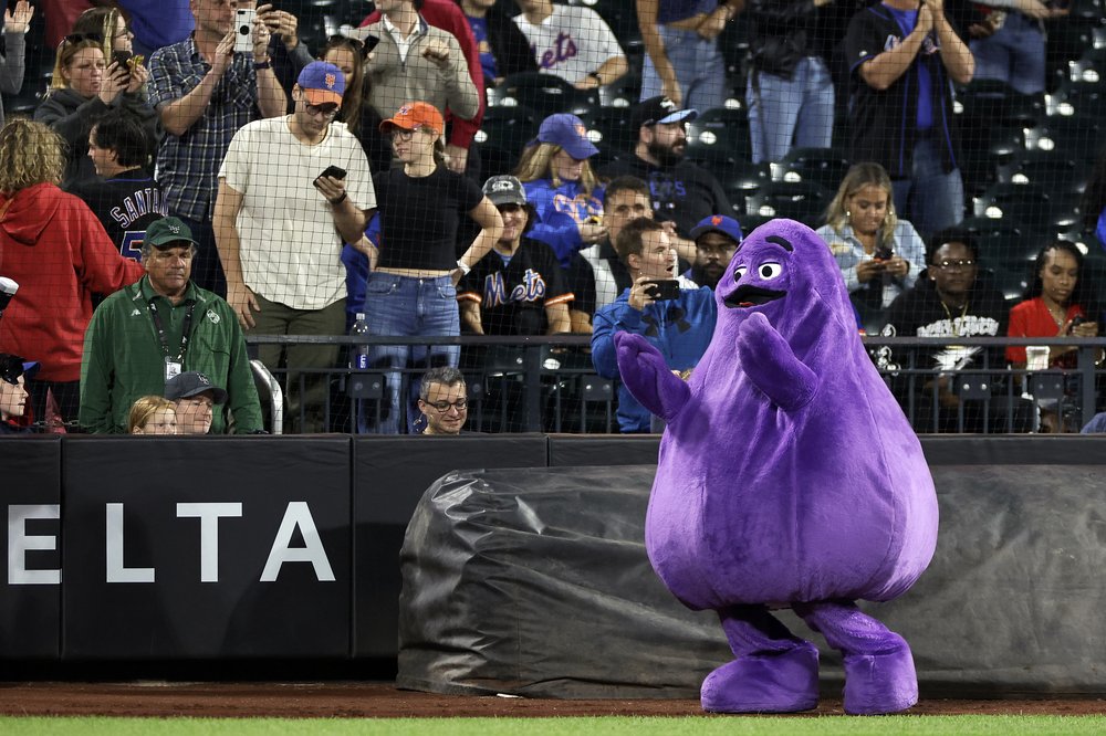 The purple McDonald's character Grimace on a baseball field.