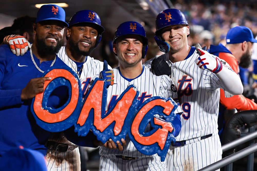 A group of baseball players with a sign that says "OMG."