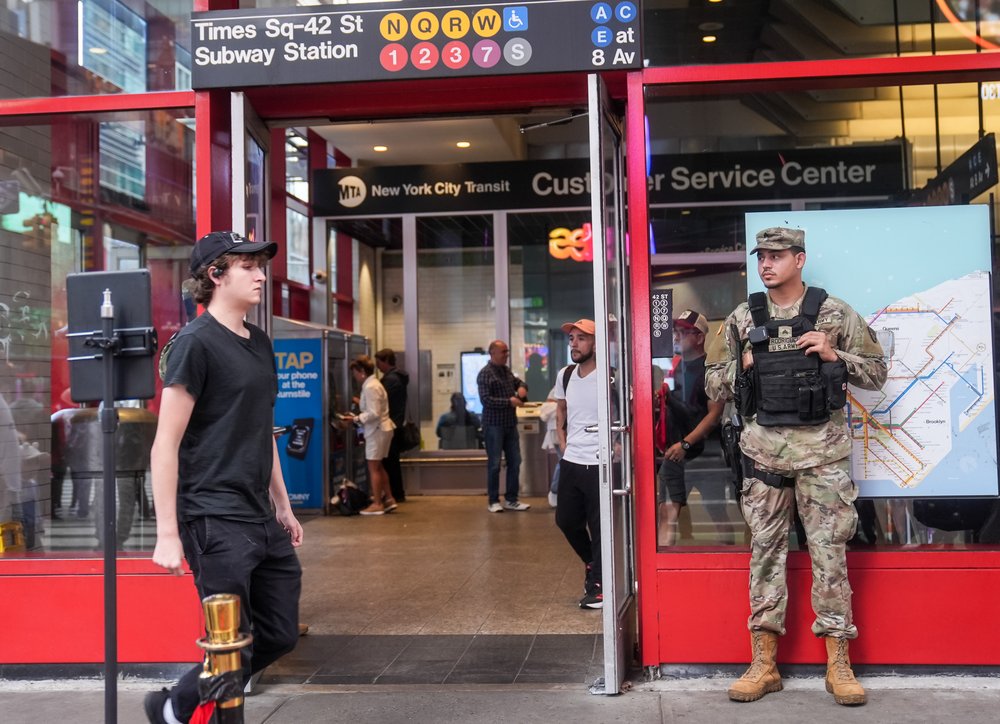 A soldier stands guard at the entrance to a subway station.