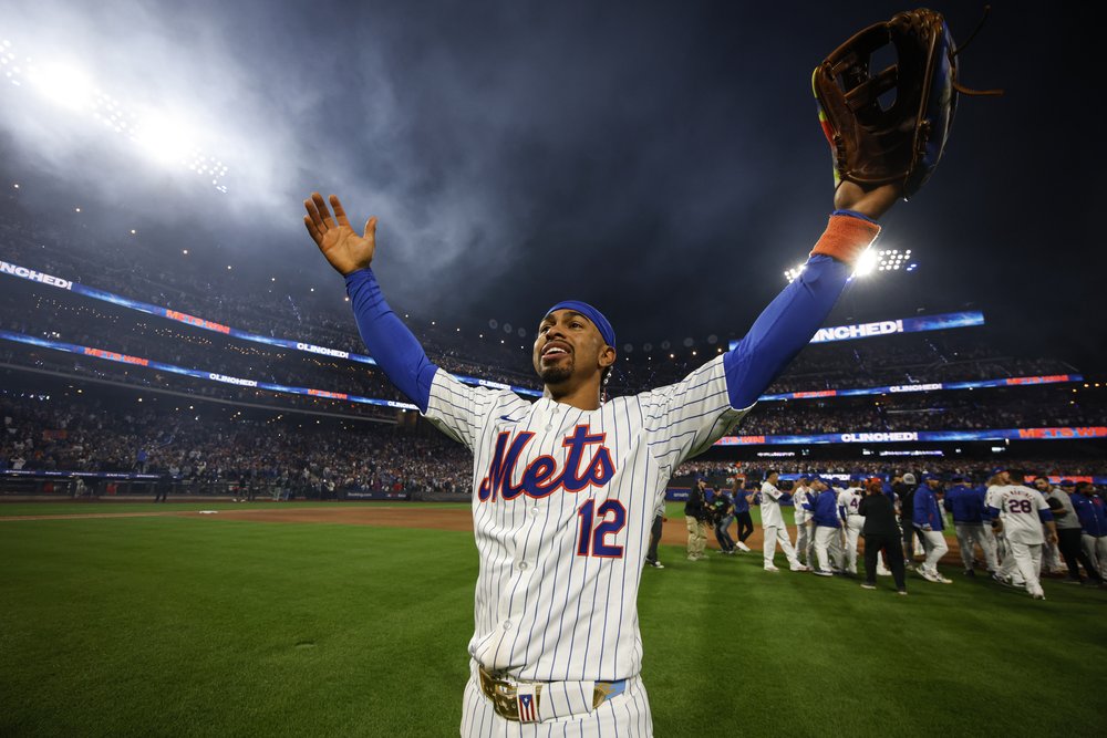 Francisco Lindor of the New York Mets, with his arms outstretched, celebrating on the field.,