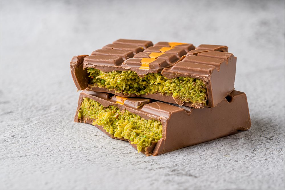 A chocolate bar with shredded pistachio inside.