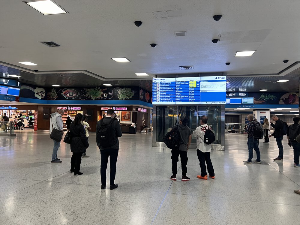Riders standing in a circle at Penn Station.
