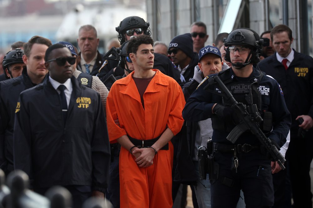 Luigi Mangione, suspect in the killing of UnitedHealthcare CEO Brian Thompson in New York City, arrives at a heliport with members of the NYPD.