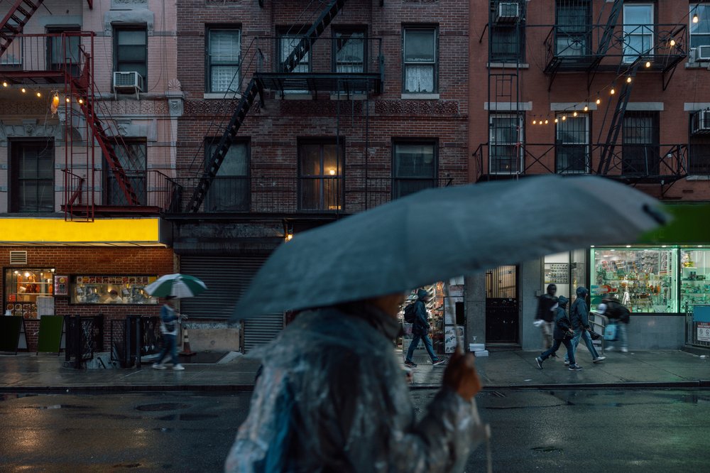 People walk in the rain in Manhattan's Chinatown in 2025.