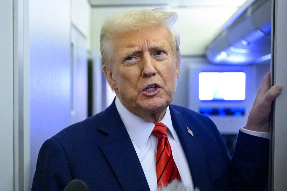 President Donald Trump speaks to reporters while in flight on Air Force One Monday.