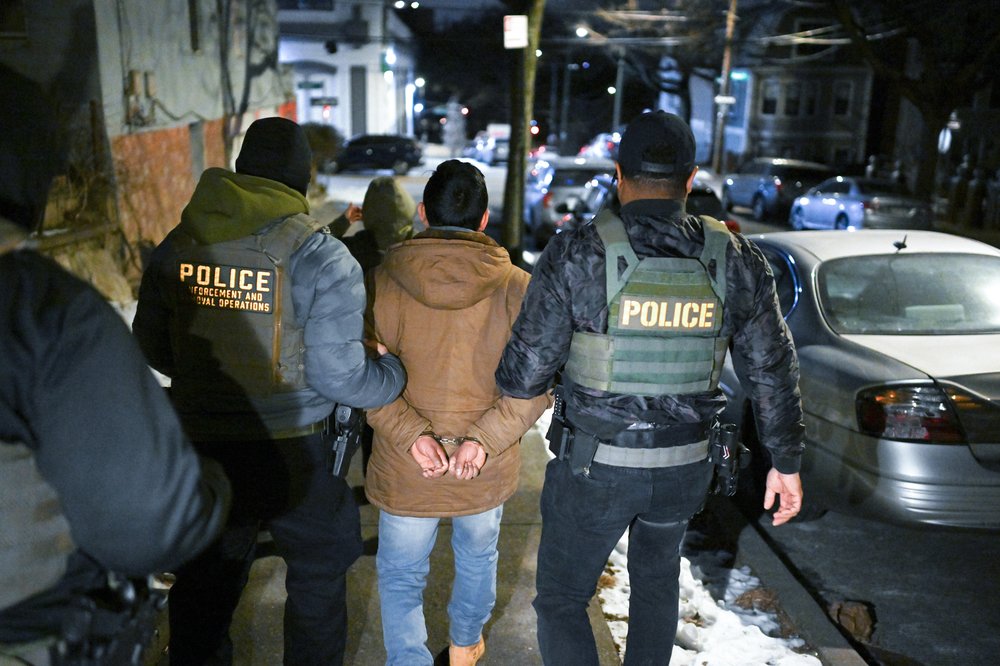 Law enforcement accompany a person detained during a federal Immigration and Customs Enforcement operation in the Bronx on Jan. 28.