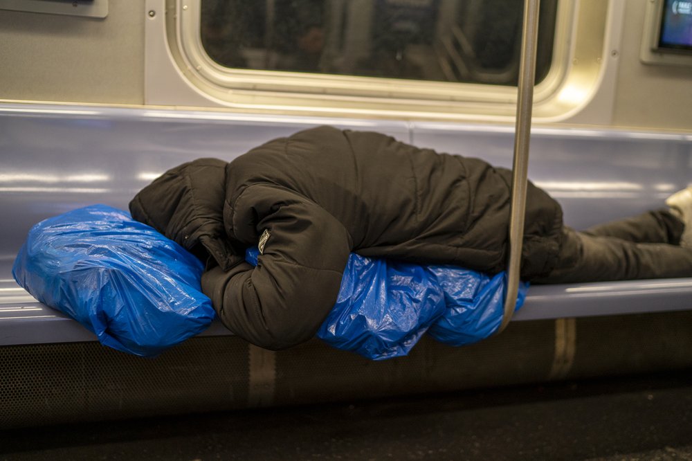 A homeless person sleeps in a subway car January 30, 2025 in New York City.