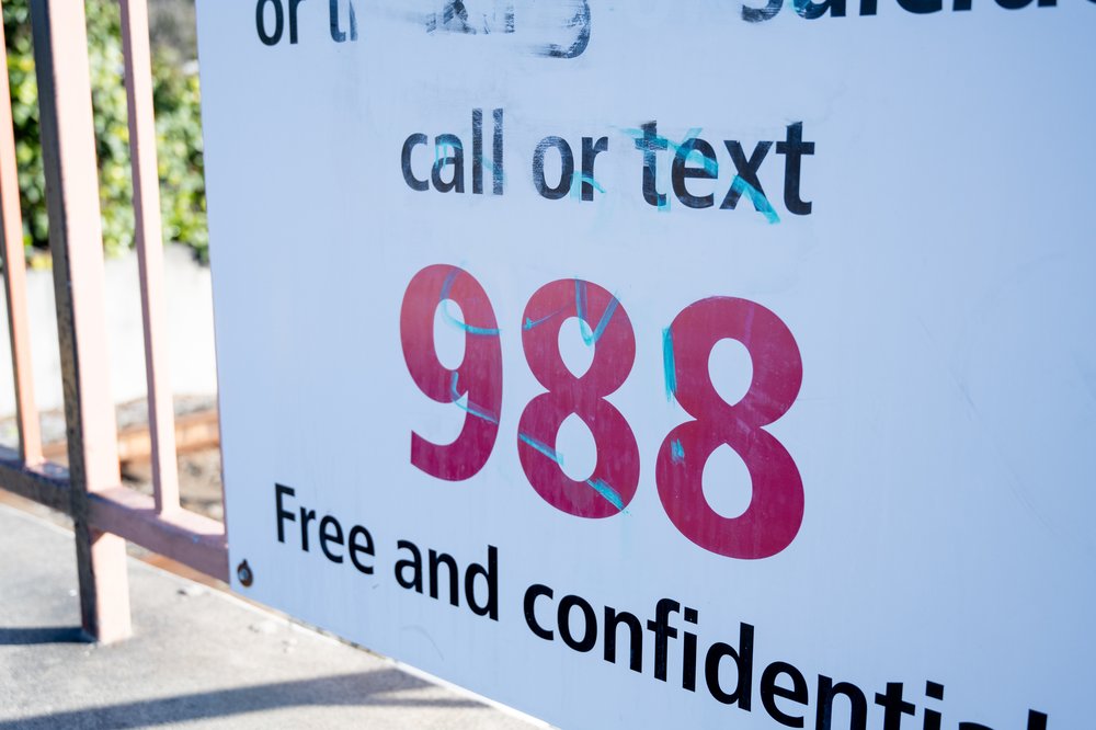 A signs for a mental health crisis helpline is posted in Lafayette, California, on Feb. 21, 2025.